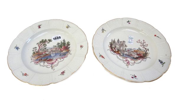 A pair of Ludwigsburg cabinet plates, circa 1770, each painted with a riverscape within a shaped basket weave wide border, blue painted and impressed