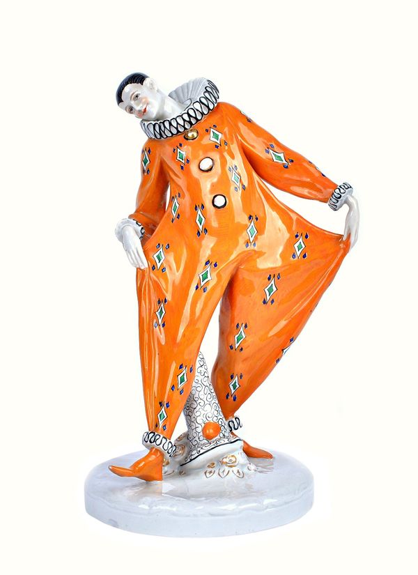 A Goebel Wilhelmsfeld porcelain Art Deco Pierrot figure, circa 1920, orange printed costume, printed and incised marks, 23.5cm high.  Illustrated