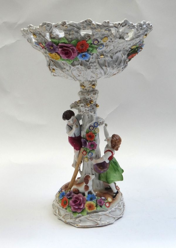 A Plaue porcelain centrepiece, 20th century modelled as a boy and girl with dog picking apples, beneath a flower encrusted and pierced  bowl, blue pri