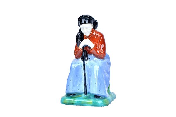 A Gmunder Keramik Austrian pottery figure, circa 1930, modelled as an old woman, seated and hunched over her walking stick, model no.359, impressed ma