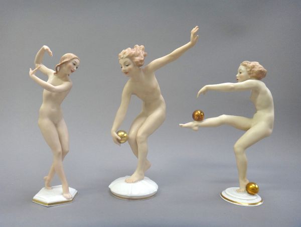 Three Hutschenreuther Austrian porcelain figures, circa 1950, each of an Art Deco female nude dancer, in various poses, two balancing gilt balls, inci