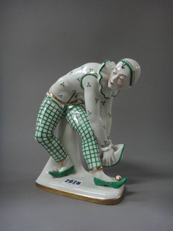 A Sitzendorf porcelain Art Deco style figure of Pierrot, mid-20th century, gilt and green on a rectangular base, green printed marks, 22cm high.