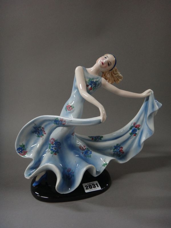 Stefan Dakon for Goldscheider; an Austrian Art Deco figure of a female dancer, circa 1930, modelled in a long blue floral print dress, model 7078, pri