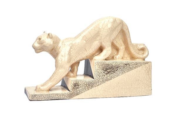 Charles Harva and Jean Andre, an Art Deco pottery model of a prowling tiger, circa 1920, with craquelure cream glaze, signed, 34.5cm wide.  Illustrate