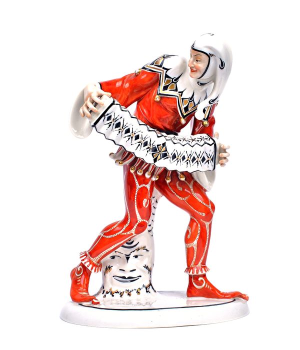 A Schwartzberger Werk porcelain figure of a jester, circa 1920, modelled standing dressed in an elaborate iron red costume, holding an accordion, inci