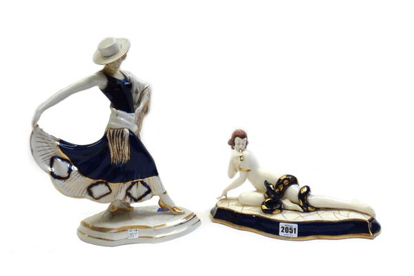 A Royal Dux porcelain figure of a snake charmer, circa 1930, modelled recumbent on a shaped base, 33cm wide, and one further Royal Dux Art Deco figure