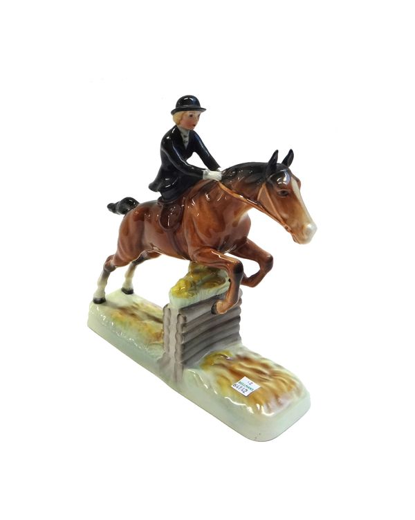 A Beswick 'Side Saddle' lady showjumper, the lady in a black jacket and hat, on a naturalistic rectangular base, printed and painted marks, 25cm high.