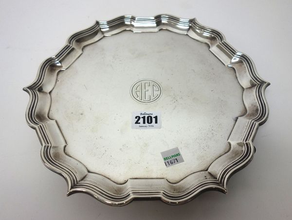 A silver salver of shaped circular form, having a pie crust rim, in the Chippendale style, initial engraved to the centre, raised on three feet, by Go