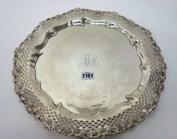 A silver salver, of shaped circular form, the pierced border having a cast border of fruiting vine, the centre of the salver monogram engraved within