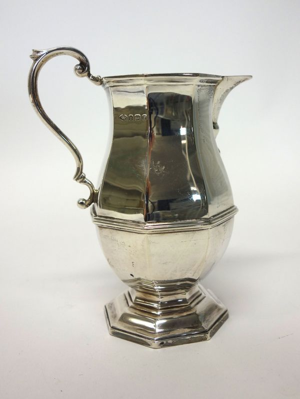 A silver milk jug of octagonal baluster form, with a scrolling handle, raised on an octagonal foot, Birmingham 1930, weight 202 gms.