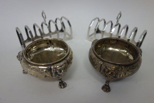 Silver, comprising; a pair of seven bar toastracks, each in an angular design, Sheffield 1935 and a pair of Victorian salts, each of circular form, ra