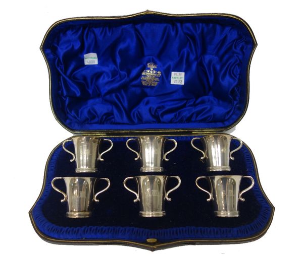 A set of six silver twin handled spirit tots, each initial engraved, London 1904, with the original fitted case, weight 192 gms.