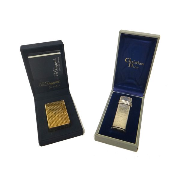 A Christian Dior Paris silver plated curved rectangular gas lighter, with plastic guarantee card, booklet, case and box and a Dupont Paris gilt metal