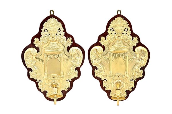 A pair of Britannia Standard silver and lightly gilt single light wall sconces, each of shaped Rococo form, decorated with a border of foliate scrolls