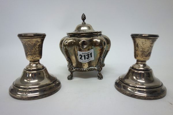 Silver, comprising; a hinge lidded tea caddy, of bombe shaped form, the lid with a wrythen knop finial and raised on four paw feet, Chester 1904, weig