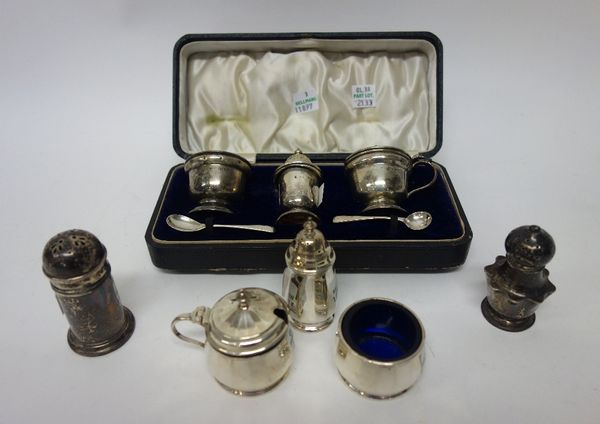 Silver, comprising; a three piece condiment set, Birmingham 1939, with two later silver condiment spoons, with a case, another three piece condiment s