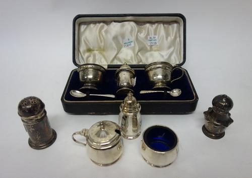 Silver, comprising; a three piece condiment set, Birmingham 1939, with two later silver condiment spoons, with a case, another three piece condiment s