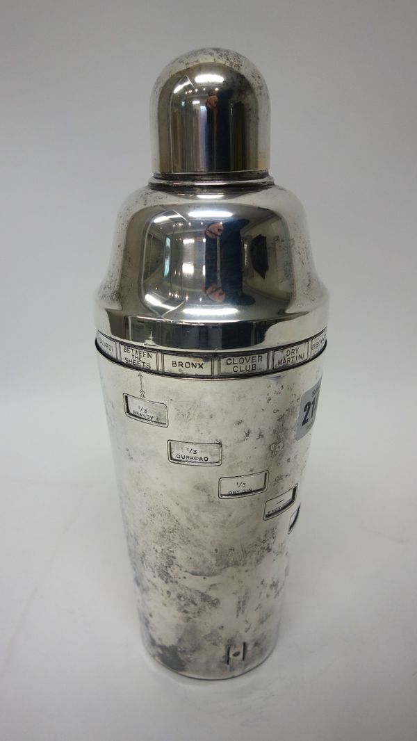 A silver plated cocktail shaker, rotating to show differing cocktail recipes, including; Sidecar, Tom Collins and Whisky Sour.