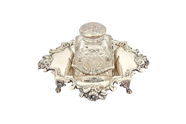 A Victorian silver inkstand, the shaped border decorated with flowers and scrolls and raised on four pierced ball and claw feet, Sheffield 1899, with