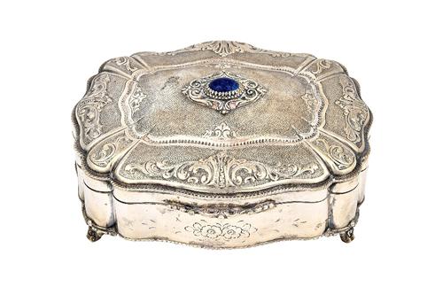 A European shaped rectangular hinge lidded box, gilt within, the hinged lid mounted with a paste imitating lapis lazuli, otherwise decorated with scro