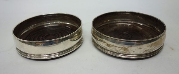 Two similar silver mounted circular bottle coasters, having differingly turned wooden bases, diameter 12.5cm, London 1987, (2).