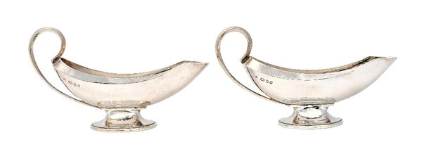 A pair of Omar Ramsden silver sauceboats, each of curved form and raised on an oval foot, detailed Omar Ramsden Me Fecit London 1931, combined weight