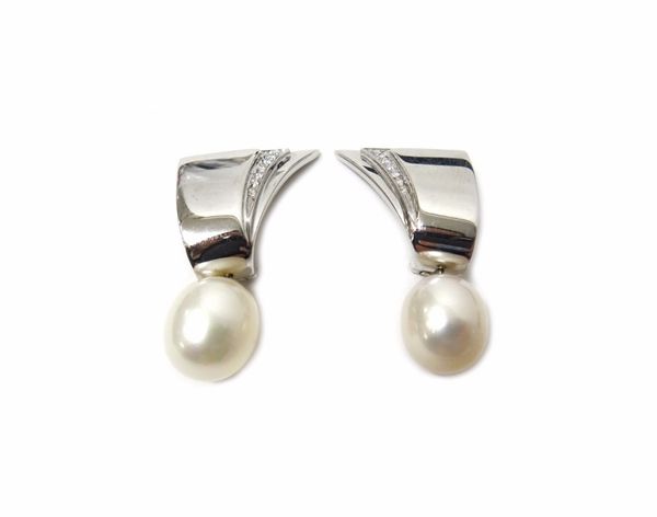 A pair of white gold, diamond and cultured pearl earclips, each of geometric design, the top mounted with circular cut diamonds and with a single cult