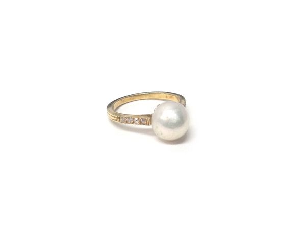 A gold, freshwater cultured pearl and diamond ring, mounted with a freshwater cultured pearl at the centre, between diamond set four stone shoulders,