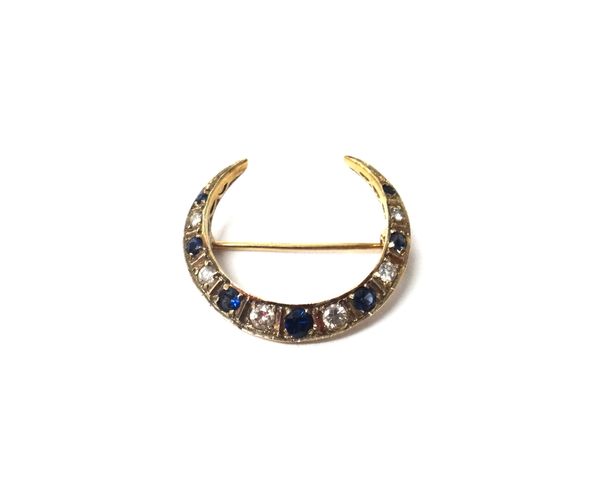 A 9ct gold, sapphire and diamond brooch, designed as a crescent, mounted with alternating circular cut sapphires and diamonds.