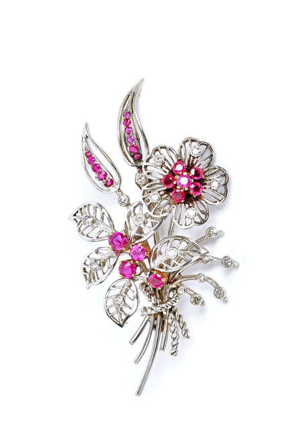 A ruby and diamond brooch, designed as a floral spray, mounted with circular cut rubies and diamonds, circa 1950s, fitted with a safety chain, with an