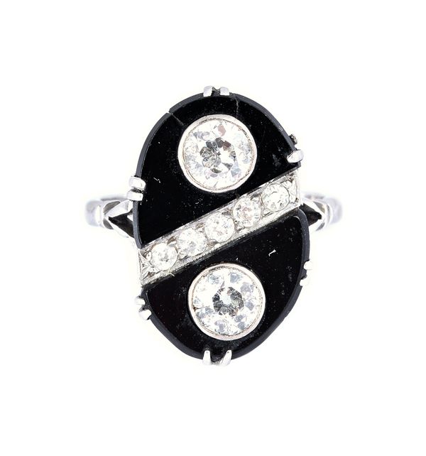 A diamond and black onyx ring, in an oval panel shaped design, collet set with the two principal cushion shaped diamonds and with a row of five smalle