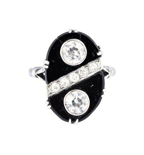 A diamond and black onyx ring, in an oval panel shaped design, collet set with the two principal cushion shaped diamonds and with a row of five smalle