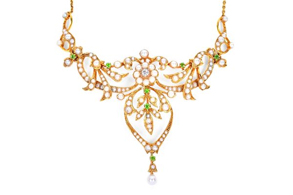 A gold, seed pearl, demantoid garnet and diamond set necklace, circa 1900, the front in a scroll pierced, foliate and cluster design, centred by a cus