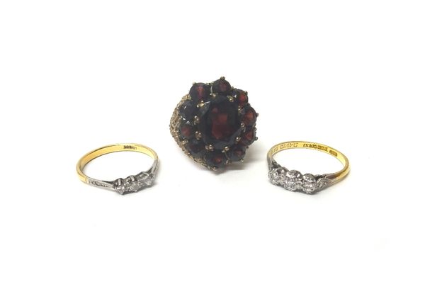 A 9ct gold and garnet set cluster ring, claw set with the principal oval cut garnet at the centre, in a surround of ten circular cut garnets, a gold a