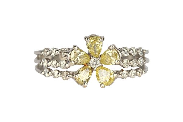 A white gold and diamond set ring, designed as a flowerhead, mounted with a circular cut diamond to the centre, in a surround of five pear shaped yell