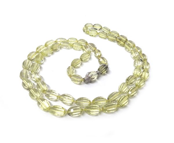 A single row necklace of oval faceted uniform citrine beads, on a diamond set citrine snap clasp, length 129cm.