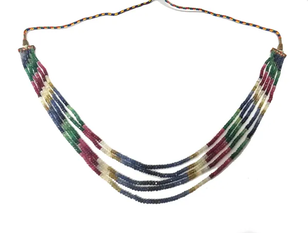 A five row necklace of faceted coloured hardstone beads, including; sapphires, rubies and emeralds, fitted to a coloured textile cord, probably Indian