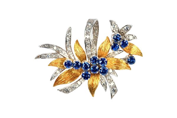 An 18ct two colour gold, sapphire and diamond brooch, designed as a foliate and floral spray, claw set with twelve circular cut sapphires and otherwis
