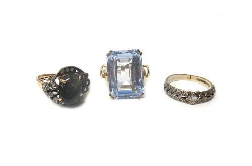 An 18ct white gold and diamond set ring, mounted with the principal circular cut diamond at the centre, between diamond set foliate sides, a gold and