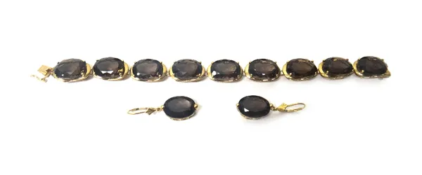 A 9ct gold and smoky quartz bracelet, claw set with a row of nine oval cut smoky quartz, on a snap clasp, length 18.5cm and a pair of gold and smoky q