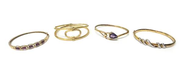 A 9ct gold oval hinged bangle, the front with a serpentine motif, a gold oval bangle, mounted with a pear shaped amethyst, detailed 375, a 9ct gold ov