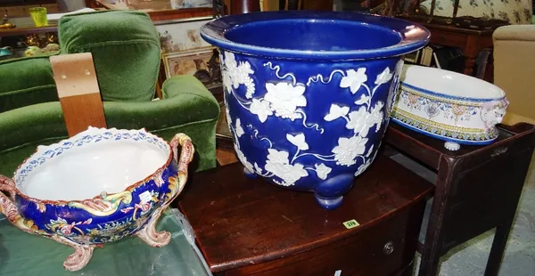 A large early 20th century style blue glazed jardiniere, moulded with leaves and berries, a faience style twin handled centre bowl and a similar oval