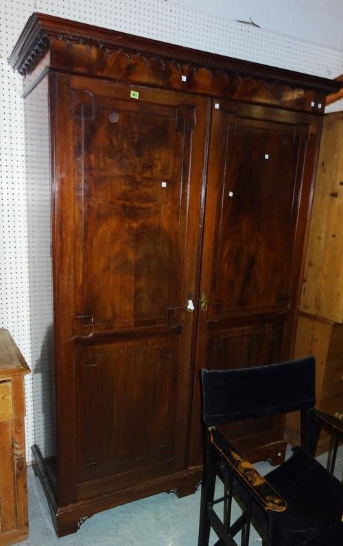 A 20th century Gothic style mahogany triple wardrobe, over a two drawer base, 153cm wide x 243cm high.   M11