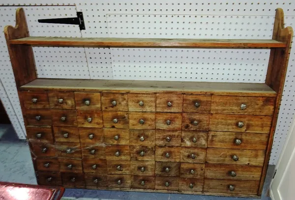 A 20th century hardwood hanging spice rack, with forty eight drawers, 113cm wide x 86cm high.   A11