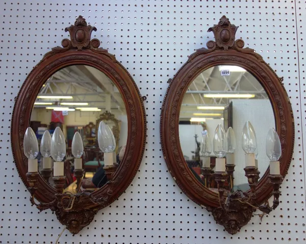 A pair of Victorian oval three light girandole wall mirrors, with cartouche carved crest, 48cm wide x 80cm high, (2).  A4