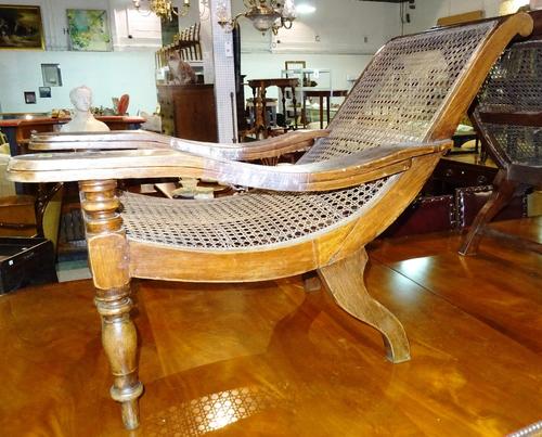 A pair of early 20th century Indian hardwood plantation chairs with caned backs and seats on turned supports (2).  H9