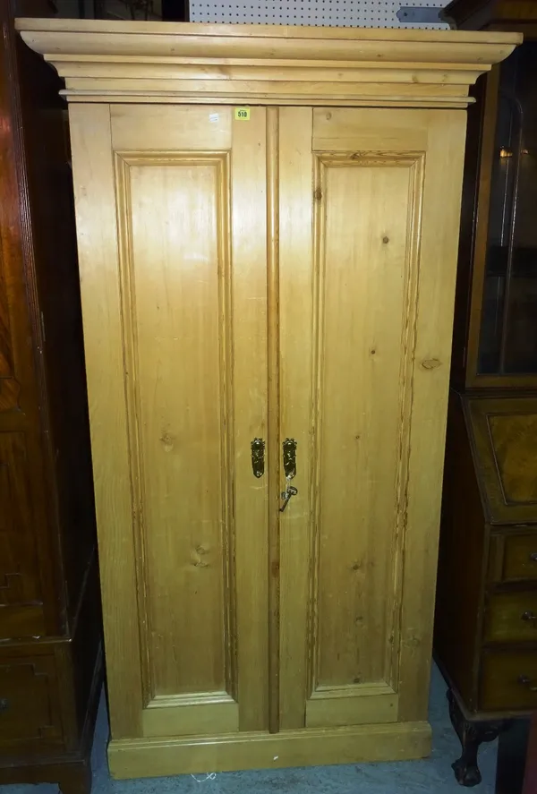 A pine small two door wardrobe, early 20th century, with two fielded panel doors, enclosing hanging space and a shoe box, 182.5cm high x 101cm wide x
