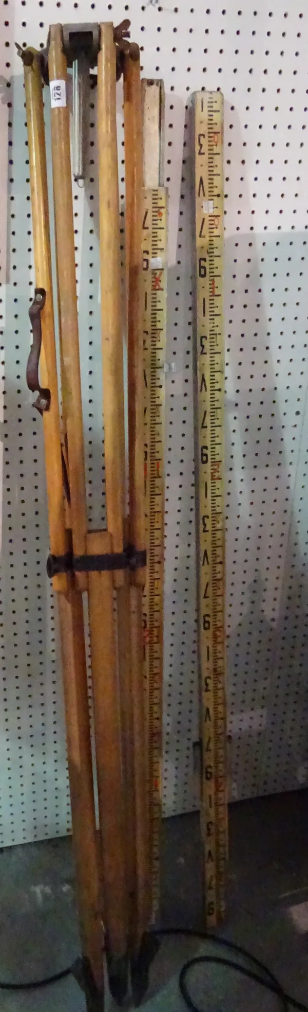 A 20th century pine surveyor's tripod and a 20th century three section metal surveyor's measuring stick, (qty).  CAB