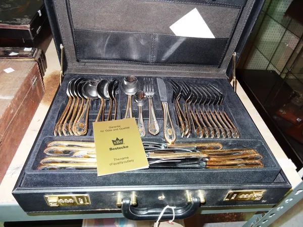 An SBS gold and silver plated canteen of cutlery, contained in a briefcase.   S1M