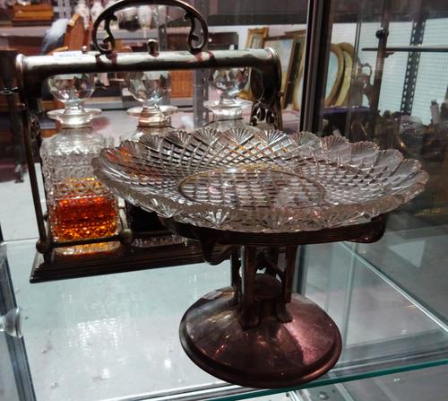 An early 20th century silver plated three division tantalus, fitted with three cut glass decanters, with Staffordshire porcelain labels and a silver p